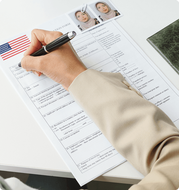 Person filling out immigration forms with U.S. flag