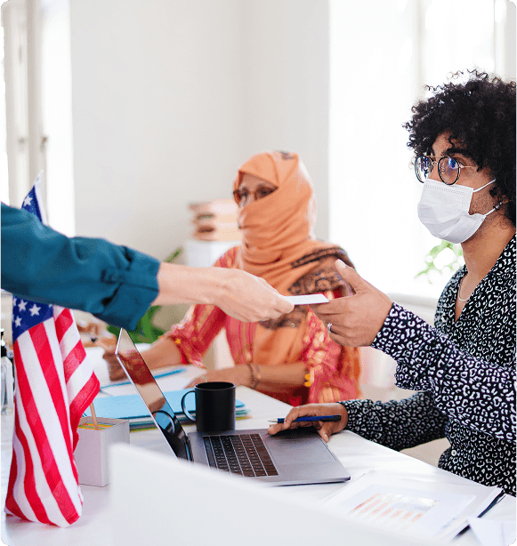 People at desk with U.S. flag reviewing documents