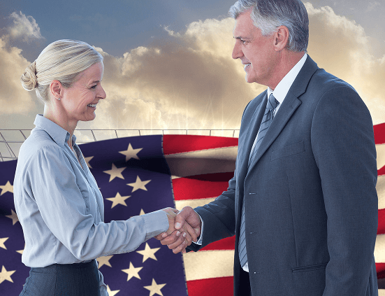 Business professionals shaking hands with American flag in background